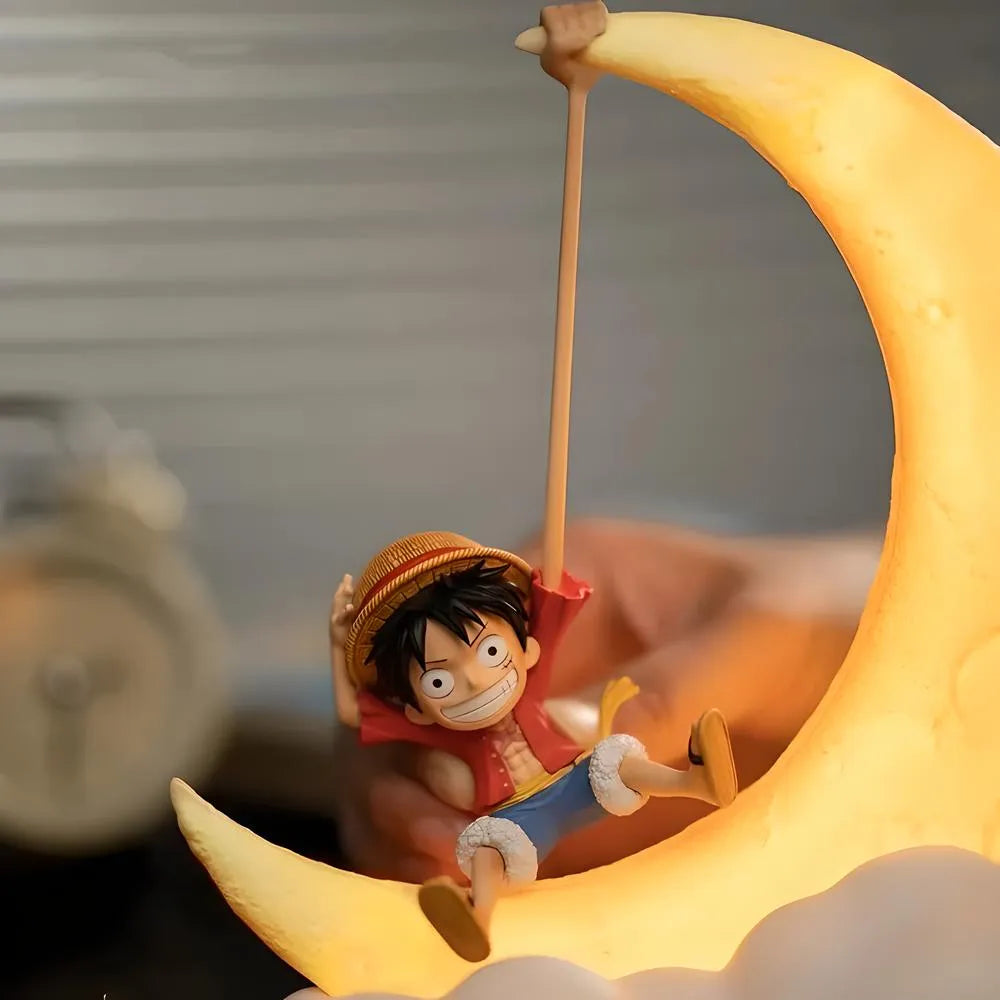 A Luffy figure sits on a glowing crescent moon lamp