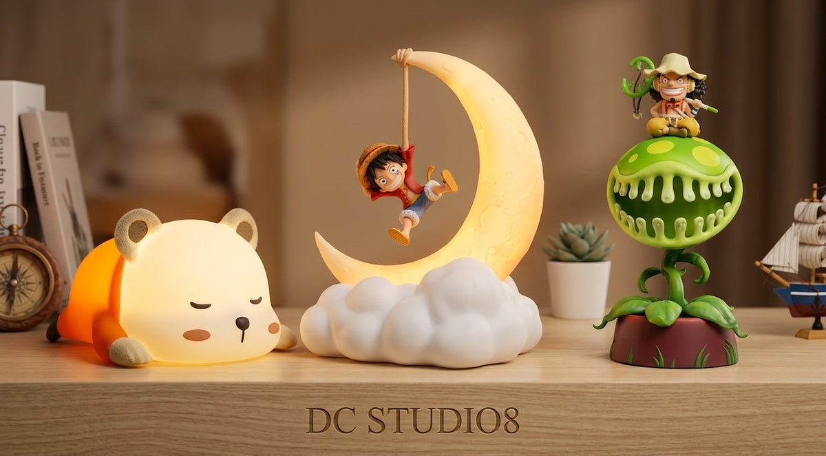 A cozy showcase of three One Piece anime lamps by DC STUDIO8 on a warm wooden desk: a sleeping Bepo night light, Luffy swinging on a crescent moon lamp, and Usopp sitting atop a carnivorous plant lamp